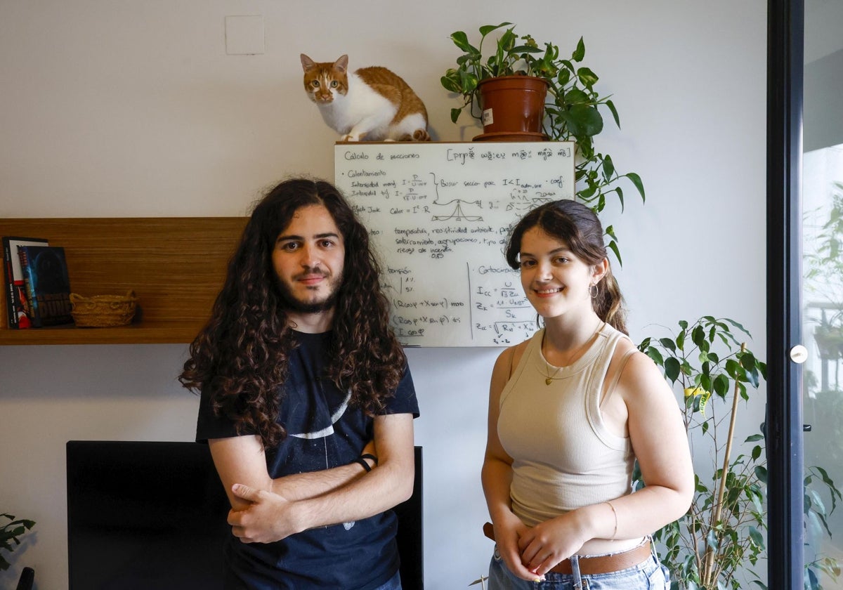 Los hermanos Ángel y Andrea, junto a anotaciones científicas del joven en el cristal de un mueble y uno de los gatos de la familia.