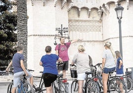 Turistas en una visita en bicicleta, junto a las Torres de Serranos.