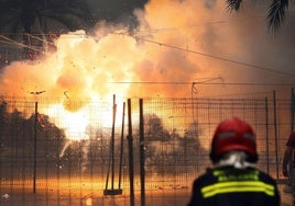 Un bombero observa el disparo de una mascletà en las Hogueras de Alicante.