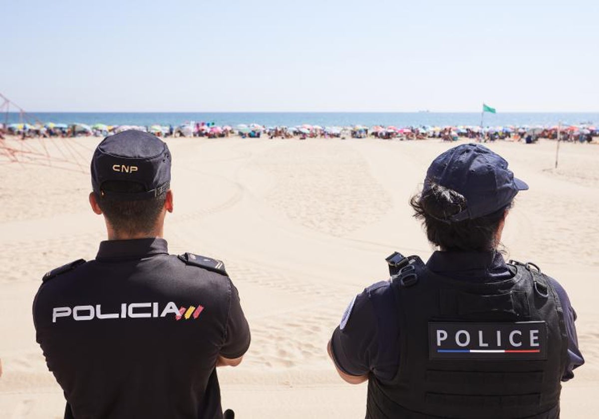 Un policía español y otro agente francés vigilan una playa en Gandia.