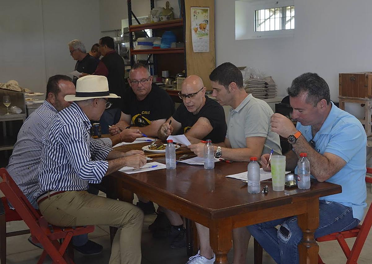 Imagen secundaria 1 - Arriba, los ganadores de esta tercera edición. A la izquierda, el jurado probando uno de los arroces. Este año se tenía en cuenta, además, el emplatado. A la derecha, uno de los concursantes, terminando su elaboración.
