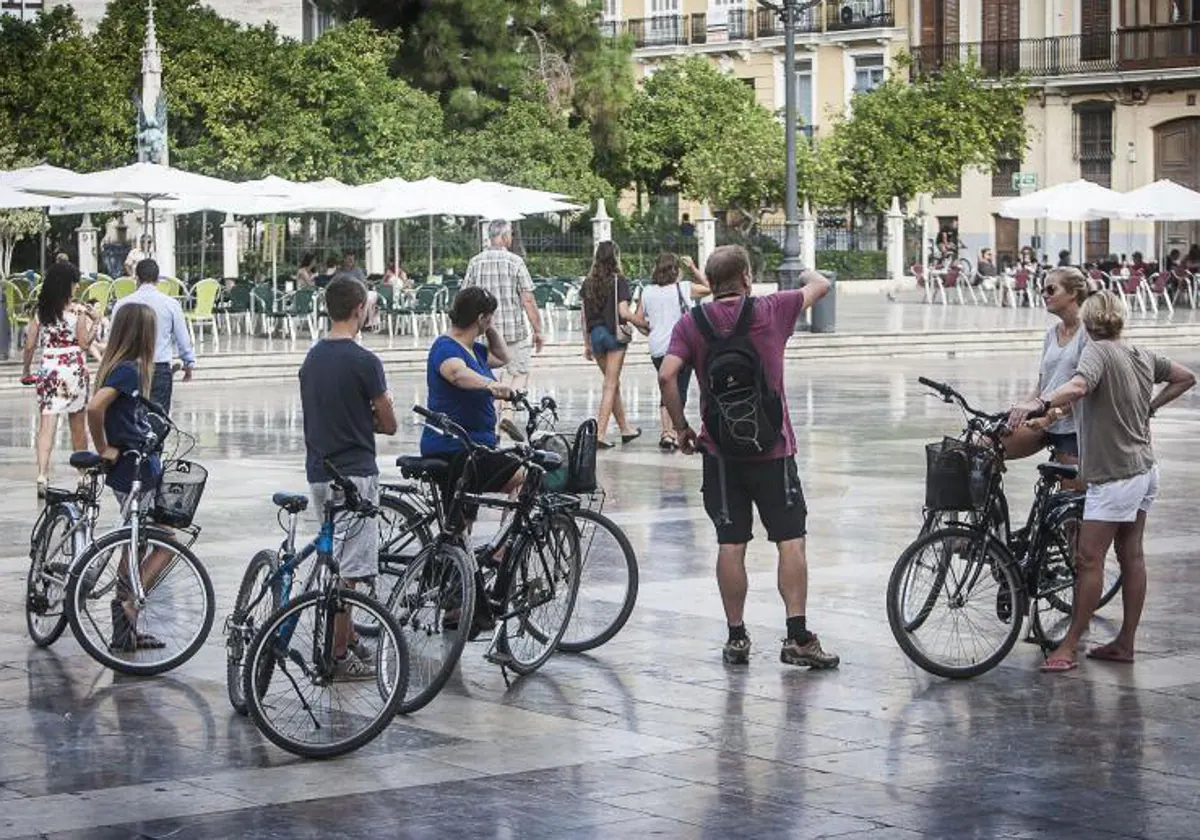 Un guía turístico da sus explicaciones a un grupo de visitantes en la plaza de la Virgen.