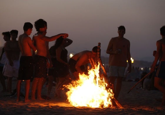 Varios jóvenes disfrutan de la celebración en las playas de Valencia.