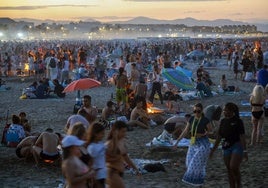 Un grupo de personas baila ante la playa abarrotada este lunes de madrugada.