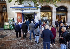 Varios jugadores hacen cola frente a una administración de Loterías y Apuestas del Estado.