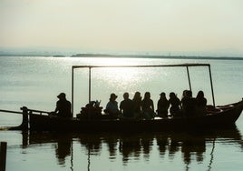 Un grupo de visitantes pasea en barca por la Albufera.