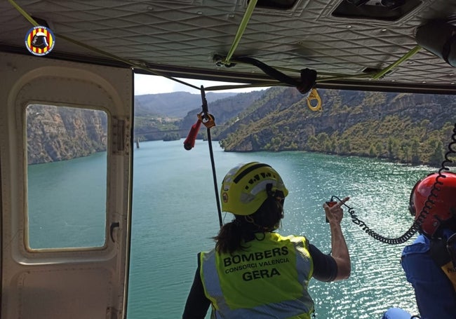 Dos de los efectivos de rescate peinan la zona desde un helicóptero.