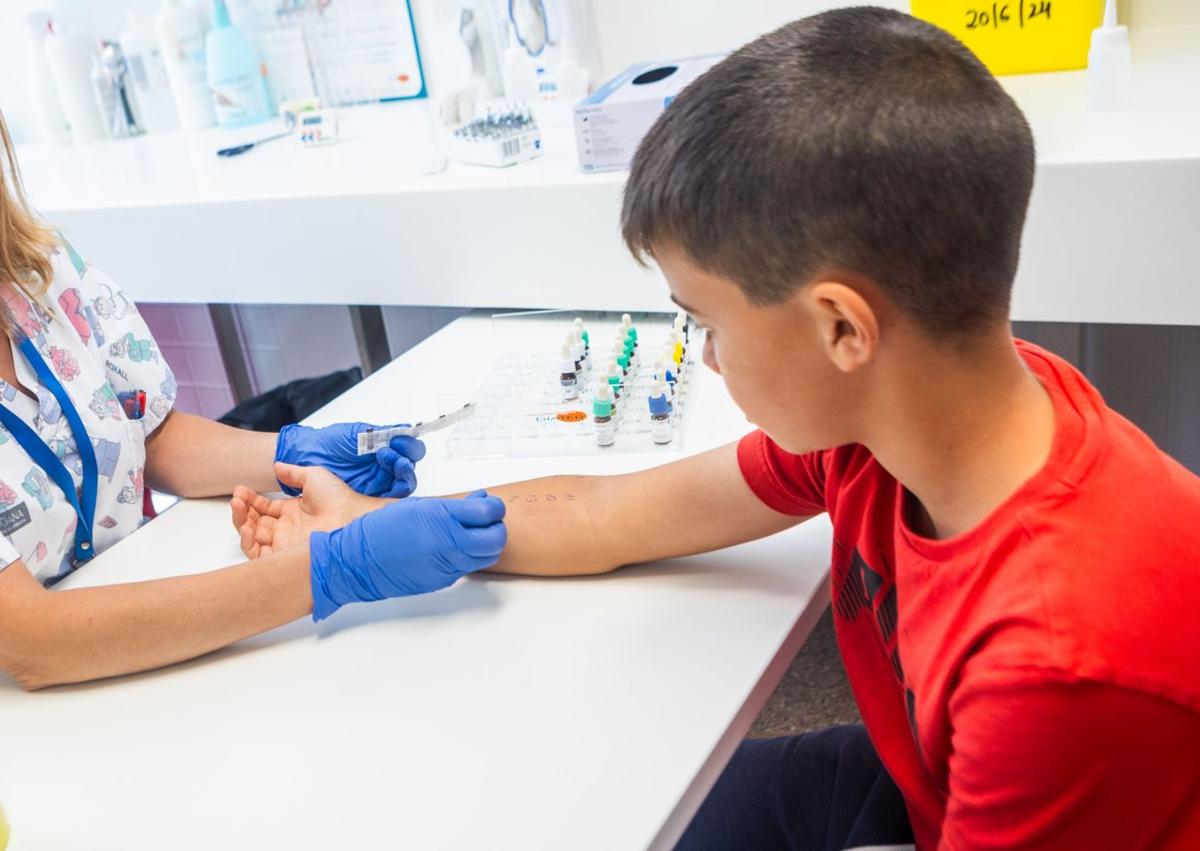 Imagen secundaria 1 - La nevera con los alérgenos; Quique, uno de los pequeños pacientes, y un 'prick test'