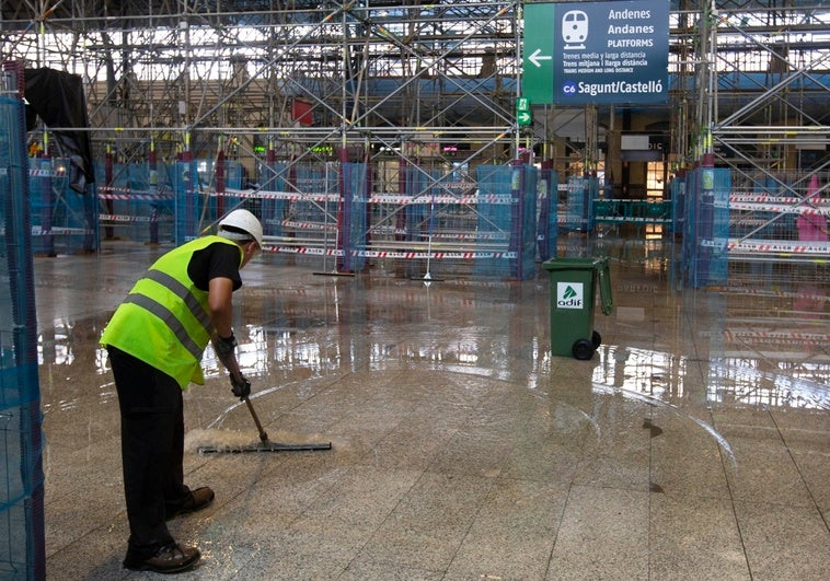 Un operario trata de despejar el agua del andén de la Estación del Norte.