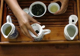 Una mujer prepara una taza de té.