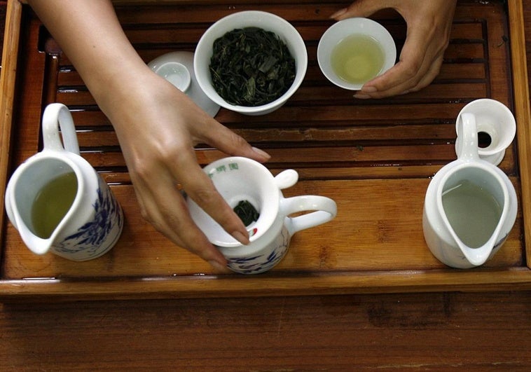 Una mujer prepara una taza de té.