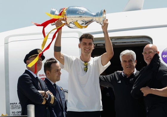 Álvaro Morata levanta el trofeo tras su llegada al aeropuerto.