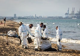 Operarios, este martes, en la limpieza de la playa de El Saler.
