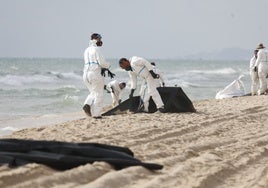 Labores de retirada del fuel en las playas del sur de Valencia.