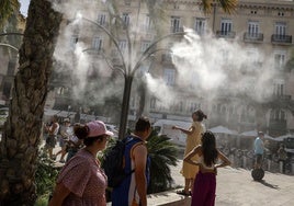 Turistas refrescandose en la plaza de la Reina de Valencia.