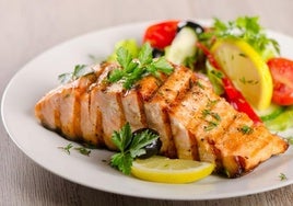 Un plato de salmón con una guarnición de verduras