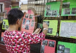 Una mujer fotografía un anuncio de vivienda en una inmobiliaria.