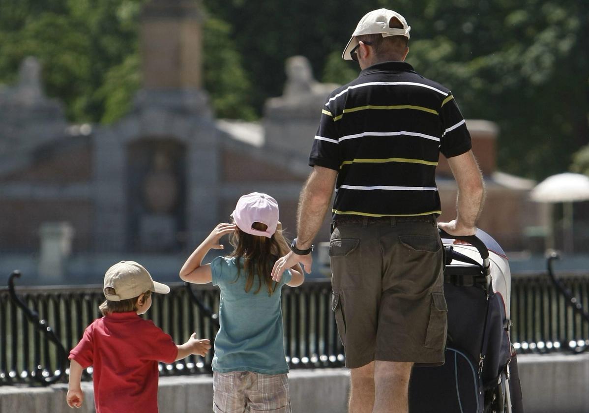 Un hombre pasea con sus hijos por el Parque del Retiro, en Madrid, en una imagen de archivo.