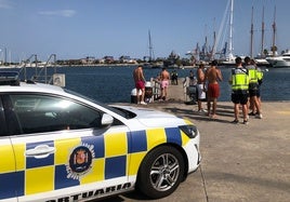 Agentes de Policía, con algunos bañistas en la dársena.