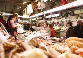 Varias personas comprando en uno de los puestos del Mercado Central de Castellón.