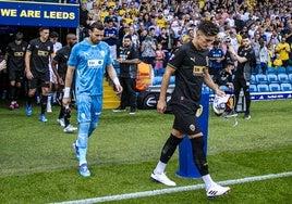 Pepelu y Dimitrievski, con gestos serios, encabezan la salida del Valencia al campo.