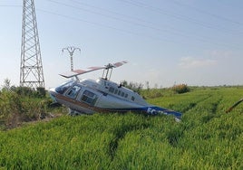 El helicóptero siniestrado, junto a la torre con el cableado eléctrico, en Alfafar.