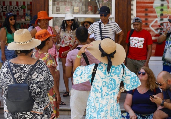 Unas personas se protegen del calor en una calle de Valencia.