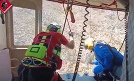 Momento en el que los bomberos rescatan al senderista con grúa hasta el helicóptero.