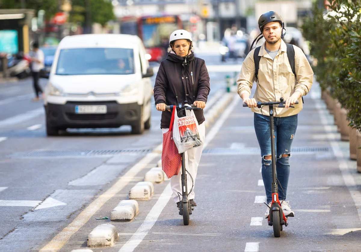 Dos patinetes eléctricos circulan por un carril bici en Valencia.