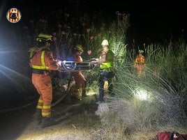 Los bomberos extraen al herido en camilla.