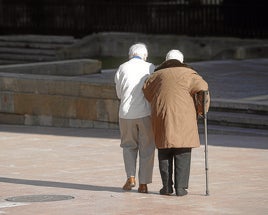 Dos ancianas pasean por una calle.