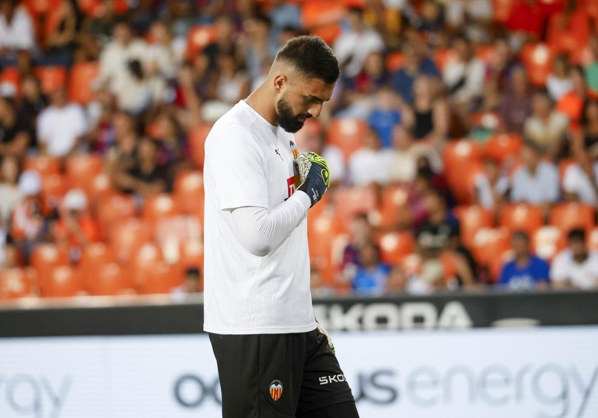 Mamardashvili se toca el escudo del Valencia durante el calentamiento.