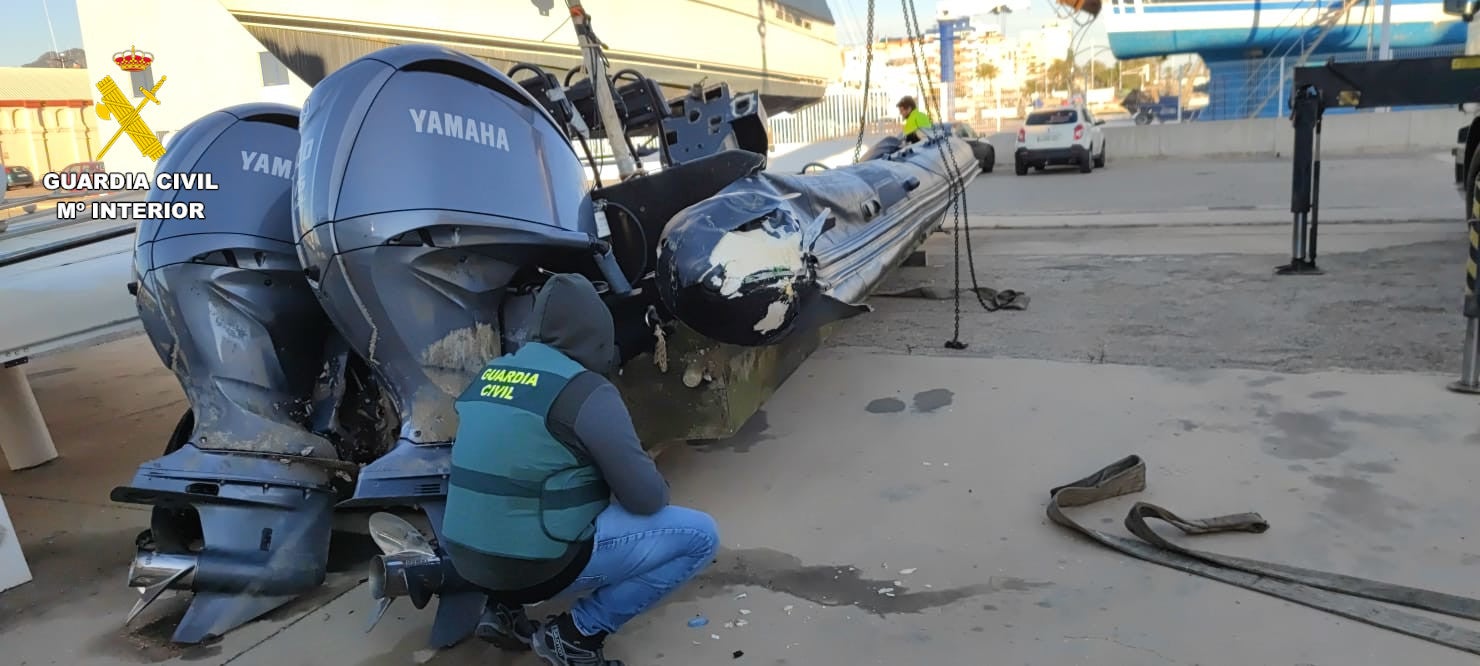 Un guardia civil, con la 'narcolancha' hallada frente a la costa de Gandia.