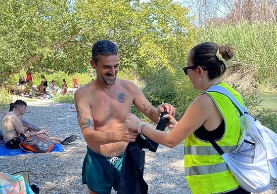 Reparto de bolsas de basura entre los bañistas.