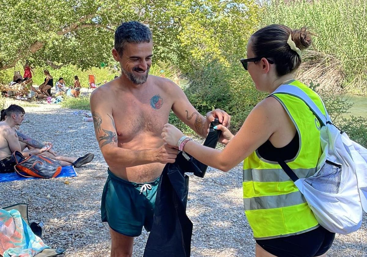 Reparto de bolsas de basura entre los bañistas.