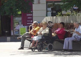 Jubilados tomando el sol en un banco.