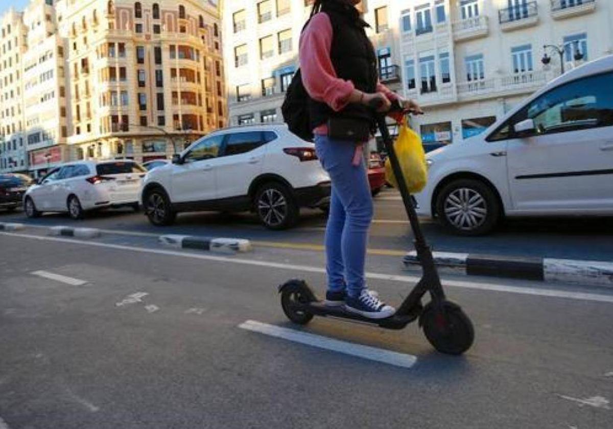 Una usuaria de patinete circula por el centro de Valencia.