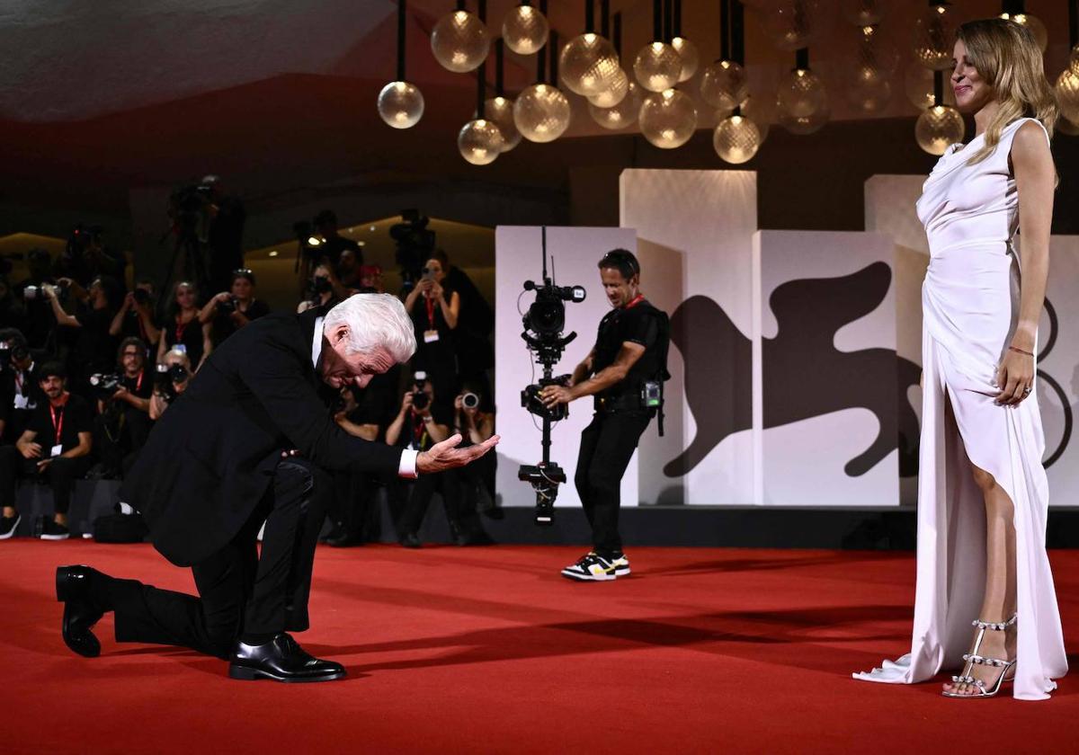 Richard Gere se arrodilla frente a su mujer, Alejandra Silva, en la alfombra roja del Festival de Venecia.