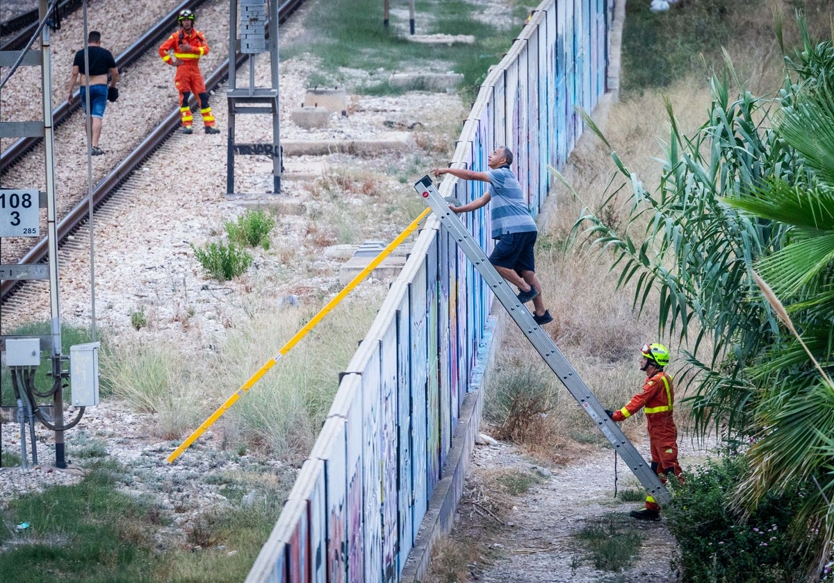 Un ciudadano marroquí habla desde una escalera con el joven para que depusiera su actitud.