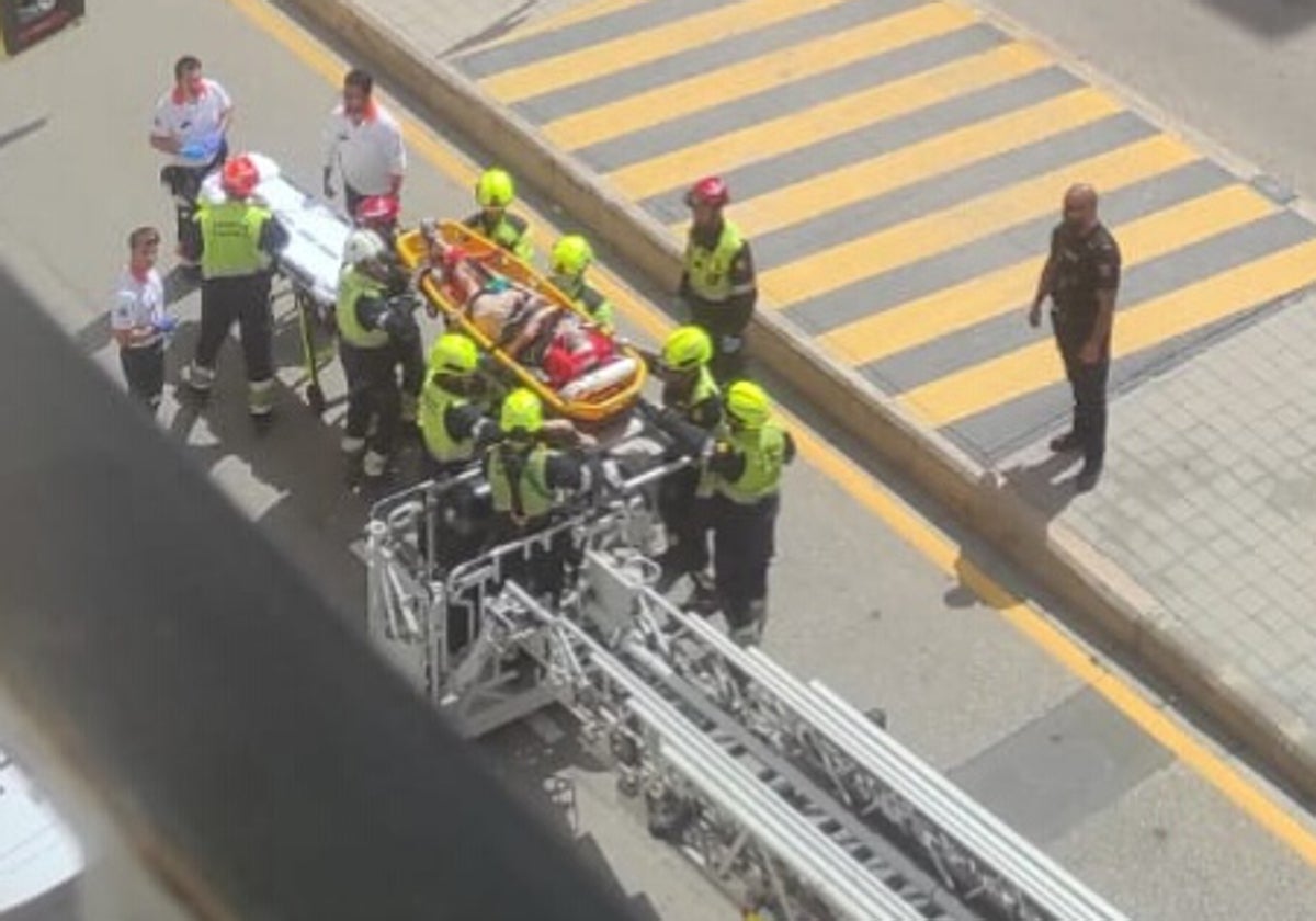 Un grupo de bomberos traslada a la víctima en una tabla de rescate.