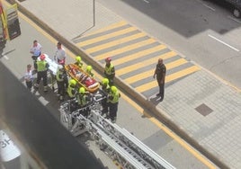 Un grupo de bomberos traslada a la víctima en una tabla de rescate.