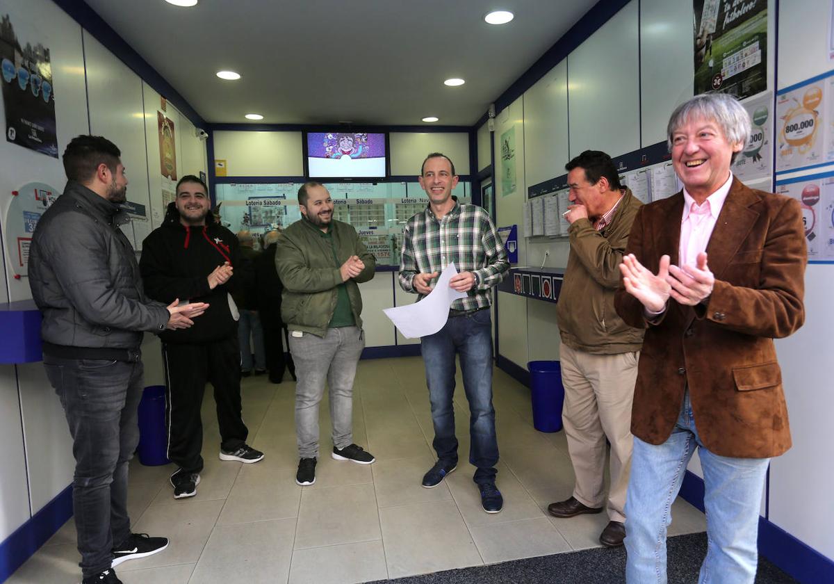 Varios ganadores celebran un premio en una administración de lotería.