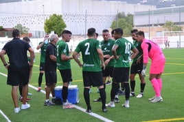 Jugadores calpinos rodeando a su entrenador.