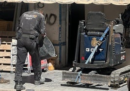 Dos policías en la puerta de la planta baja donde buscaron restos humanos.