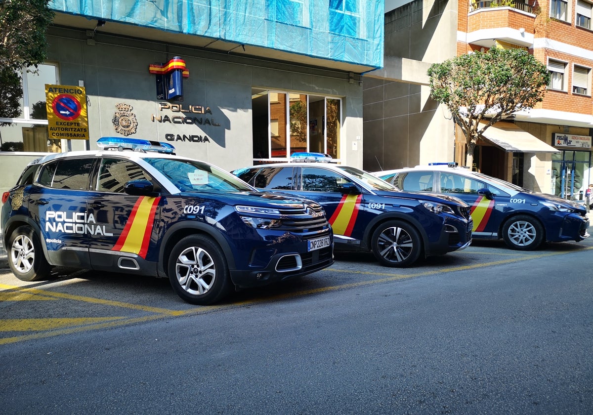 Tres coches patrulla aparcados junto a la comisaría de Gandia.