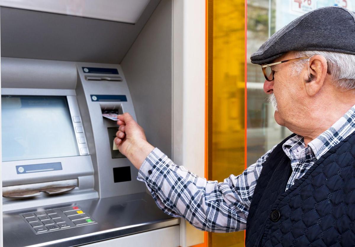 Un jubilado saca dinero del cajero automático en una imagen de archivo.