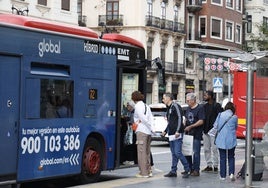 Pasajeros en un parada de la EMT en la calle Xàtiva.