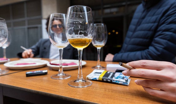 Una mujer fumando en un bar.