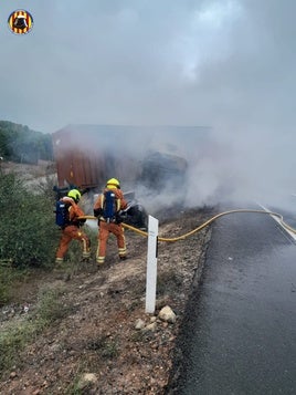 Los bomberos sofocan el camión incendiado.