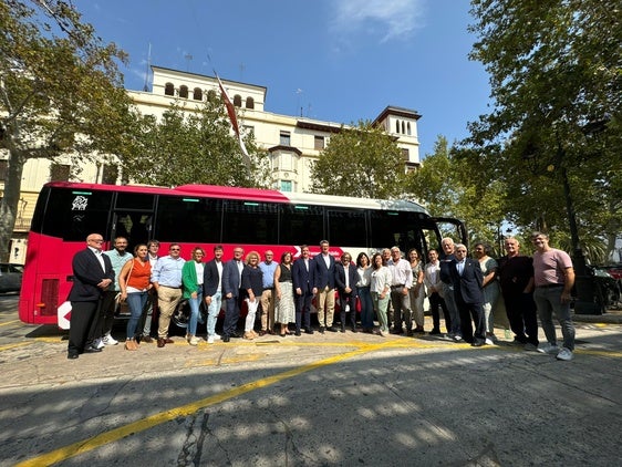 Alcaldes y alcadesas, junto al conseller, delante de uno de los nuevos autobuses que cubren la línea.